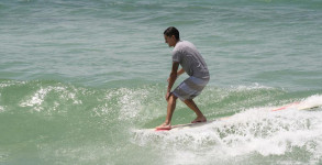 Alex Gossman at the Cross on Pensacola Beach hanging five on his longboard