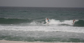 Surfers taking off on a wave by the Pensacola Beach Gulf Pier on June 2012