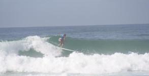 Cathy Harding of PensacolaSurf riding a wave on her longboard at the Cross on Pensacola Beach