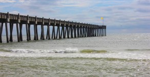 Pensacola Beach Gulf Pier with a yellow flag flying in hard offshore wind