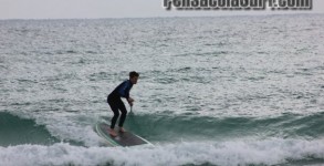 New Years Eve 2012 Midday standup paddleboarder Alex Gossman riding a wave on Pensacola Beach, FL beside the Fishing Pier