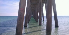 Pensacola Beach Gulf Pier underside with flat, clear Gulf of Mexico water